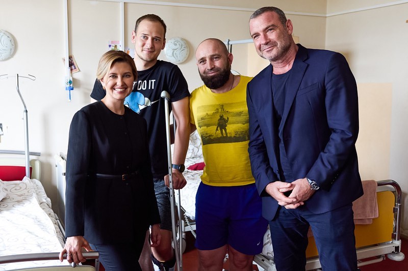 У трендовому жакеті без коміра та балетках: Олена Зеленська разом із голлівудським актором відвідала поранених солдат